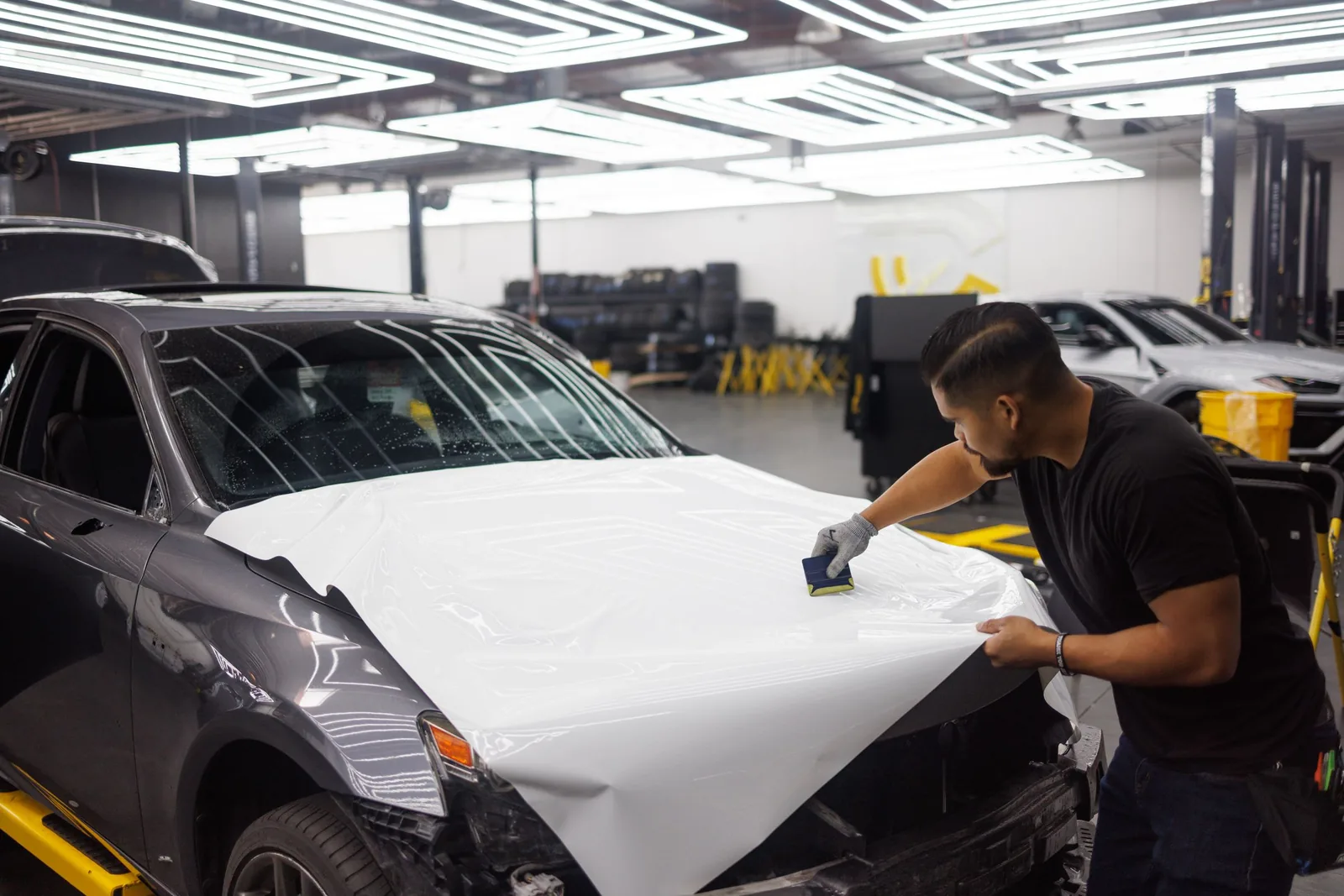 DRESDEN technician squeegeeing protection film across the bonnet of a car